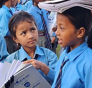 Two schoolgirls reading together